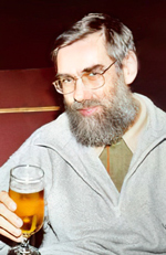 Graubärtiger Mann mit Brille und einem Glas Bier