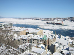 Verschneite Dächer und ein Schiff im vereisten Hafen.